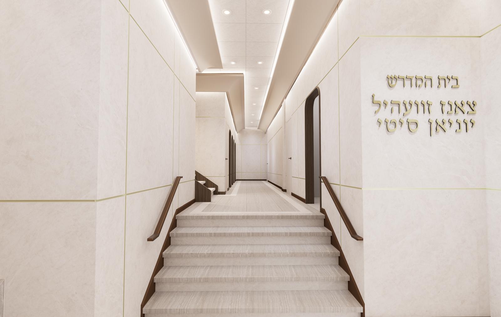 Axial view up the entry stair toward dimensional Hebrew lettering on the stone wall