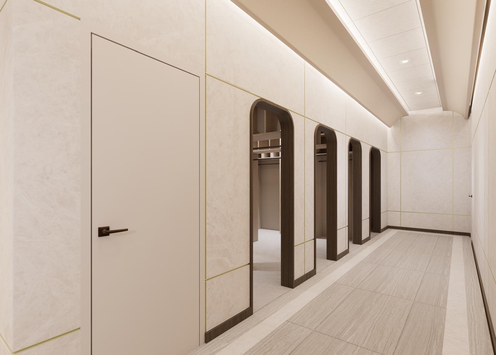 Corridor lined with arched timber coat alcoves, indirect cove lighting and travertine flooring