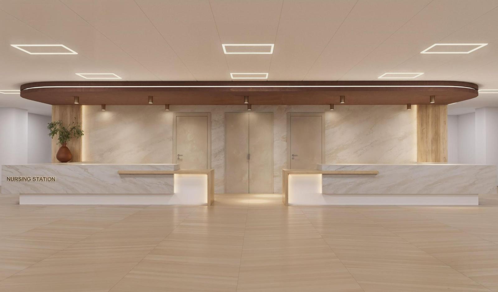 Nursing station with marble-clad counters, curved walnut soffit and warm cove lighting