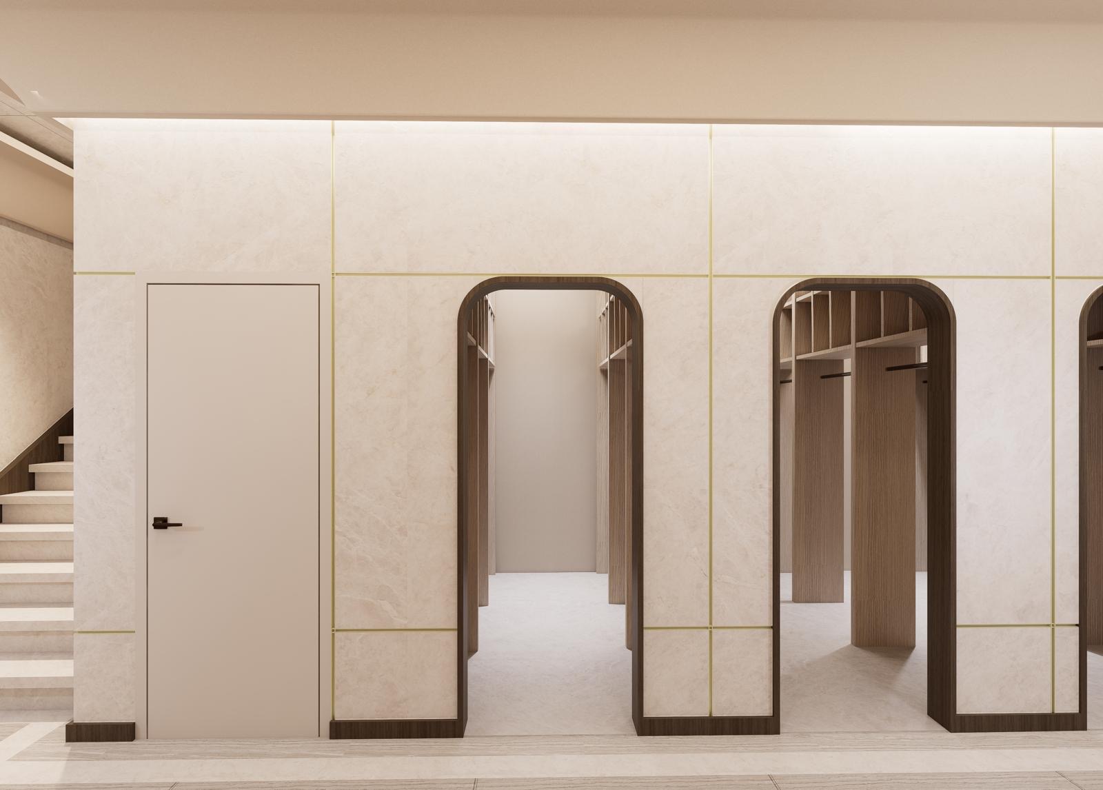 Row of arched openings leading to timber coat alcoves off the main corridor